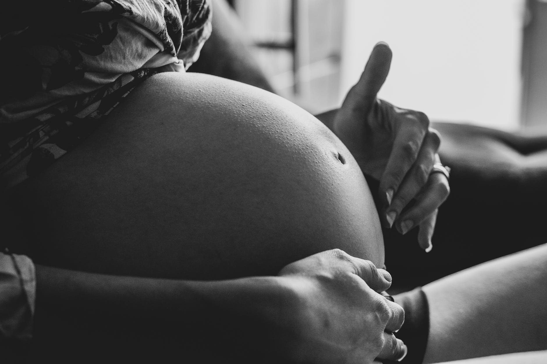 crop pregnant woman touching belly belly while resting on couch